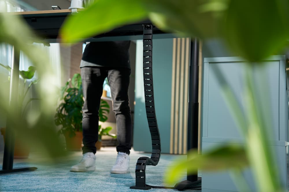Zwarte Dataflex kabelrups voor netjes kabelmanagement onder een sta-bureau.